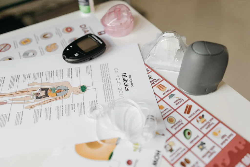 A comprehensive flat lay of diabetes management tools including a glucose meter and instructional flyers.