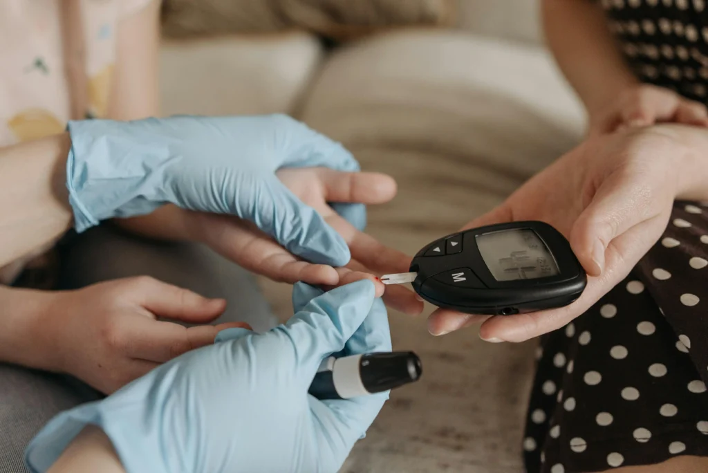 Hands measuring blood glucose levels with a glucose meter and test strip.